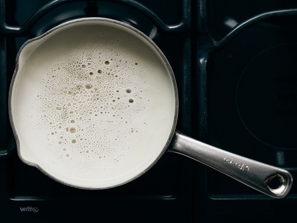 Milk simmering in saucepan on stovetop