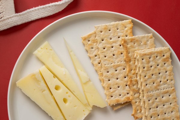 Swiss cheese wedges and club crackers on white plate