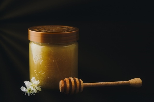 Jar of honey and adjacent honeycomb