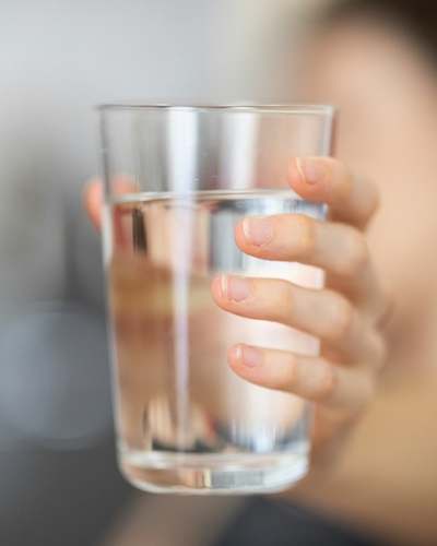 Water glass held toward camera